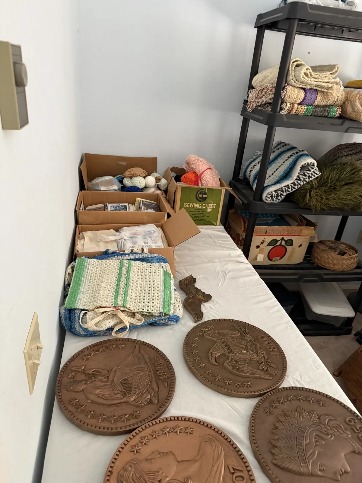 Tables and shelves of linens, baskets, boxes and small estate-sale collectibles.