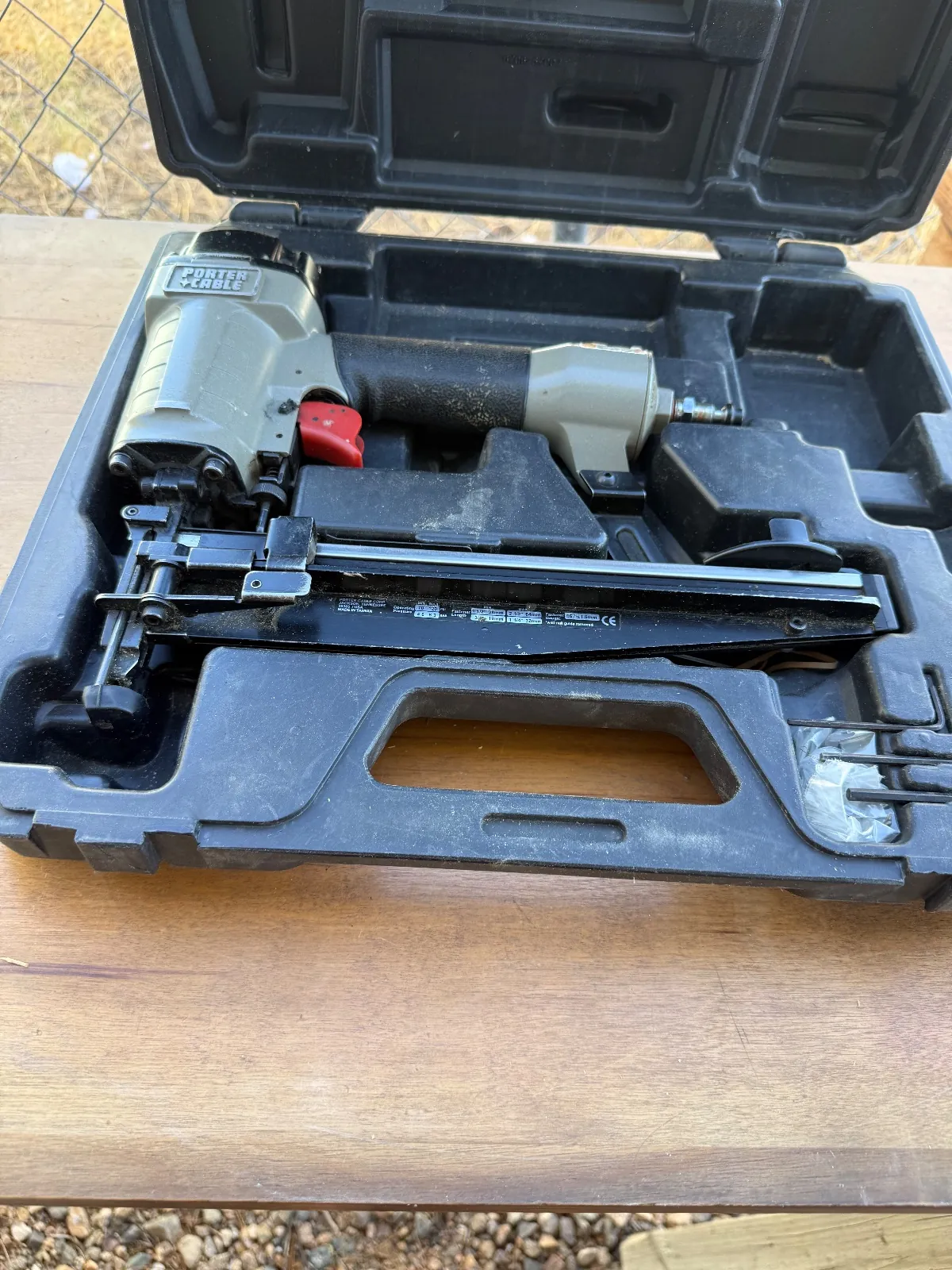 Nailer and accessories displayed inside their fitted carrying case.